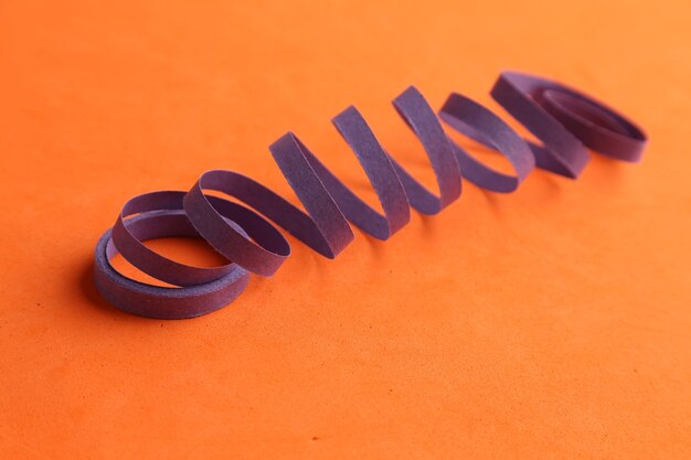 Serpentina de fiesta púrpura aislado sobre un fondo naranja