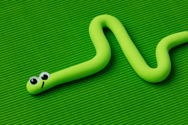 Serpiente de plastilina de alto ángulo con fondo verde