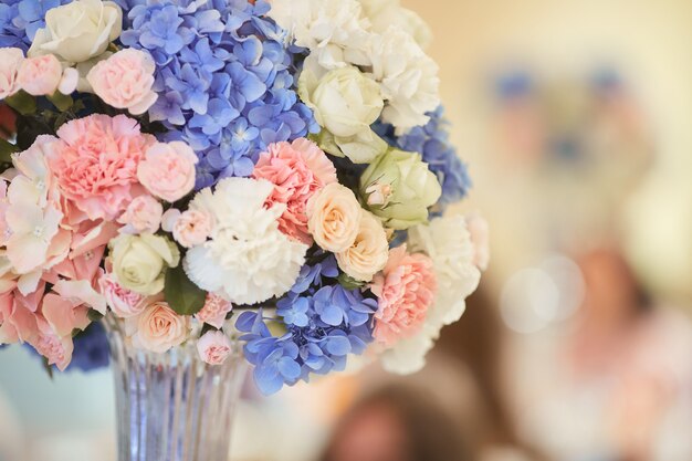 Servicio de mesa de bodas. Ramo de hortensias rosadas, blancas y azules se encuentra en la mesa de la cena