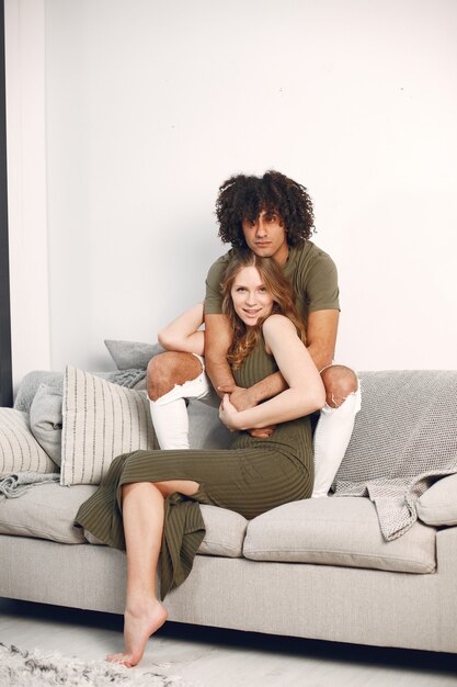 Sesión de fotos.Feliz pareja joven en casa en el sofá. Abrazar, besar.