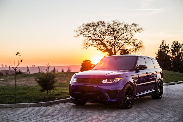 Una sesión de fotos de jeep azul en la puesta de sol.