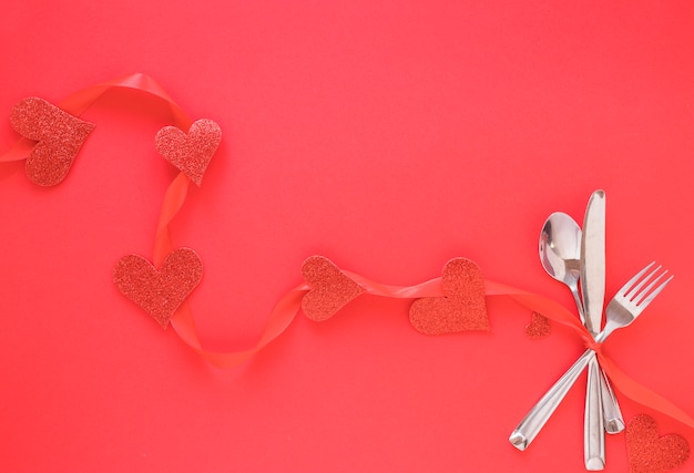 Set de cubiertos con corazones rojos.