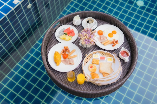 Set de desayuno flotando alrededor de la piscina