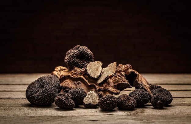 Setas de trufas negras en mesa de madera rústica con espacio de texto libre