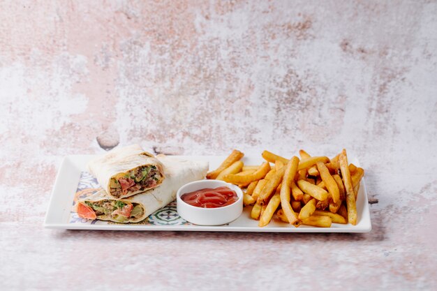 Shaurma comida tradicional dentro de pan lavash con papas fritas y salsa de tomate.