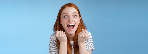 Foto gratuita sí, una noticia increíble, una chica pelirroja sorprendida, muy atractiva, animando, apretando los puños, gritando, sí, ac.