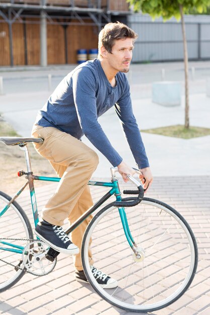 Sideview hombre montando bicicleta al aire libre