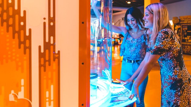 Sideways happy women playing arcade game