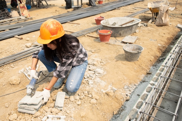 Foto gratuita sierra redonda en manos del constructor, trabajo en colocación de losas.