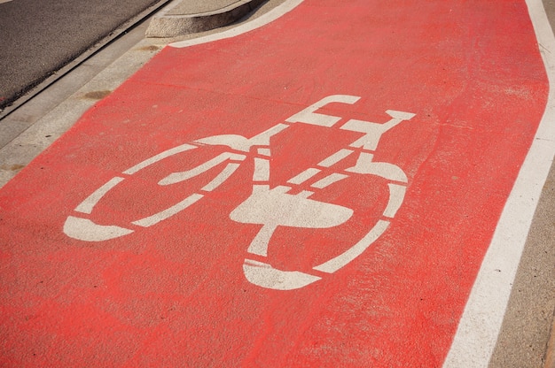 Signo de bicicleta sobre un fondo rojo en la calle