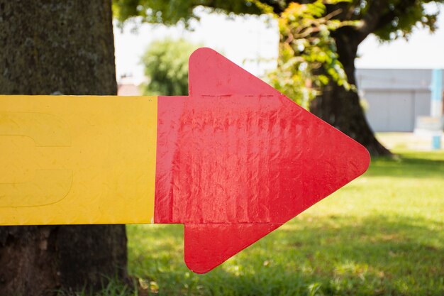 Signo de flecha roja y amarilla hecha de cartón
