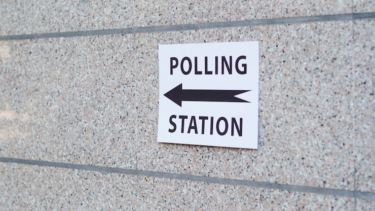Foto gratuito signo de la mesa electoral con dirección en la pared