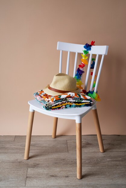 Silla con pila de camisas hawaianas y sombrero