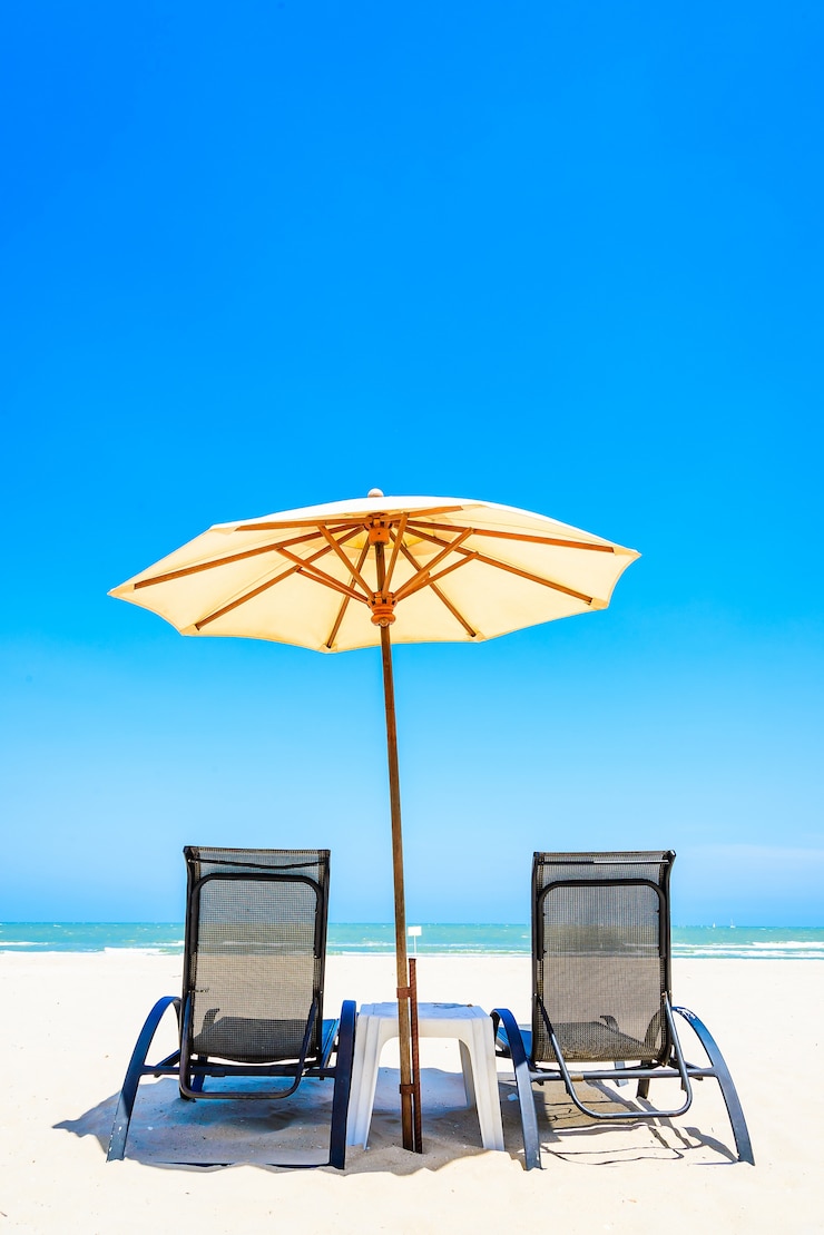 Foto gratuito silla de playa con sombrilla