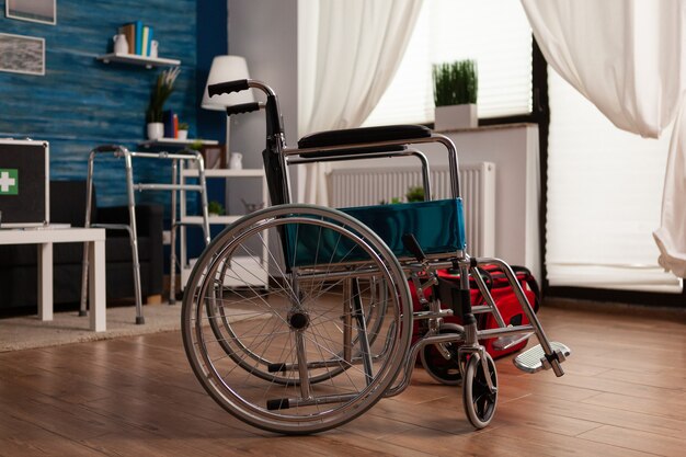 Silla de ruedas medial del hospital de pie en la sala de estar vacía sin nadie en él