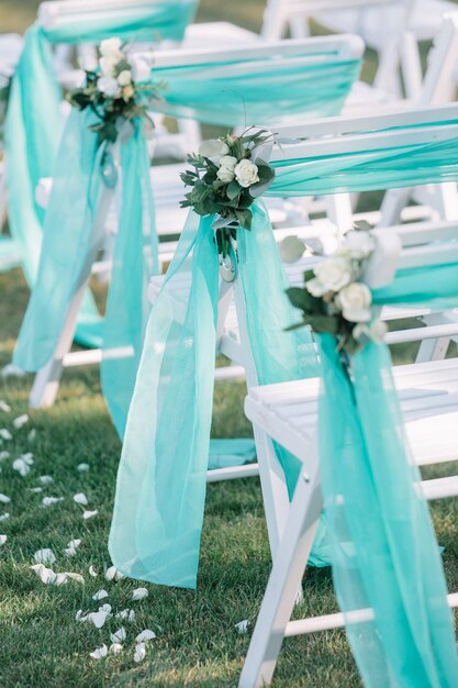 Sillas blancas para invitados decoradas con tela de menta