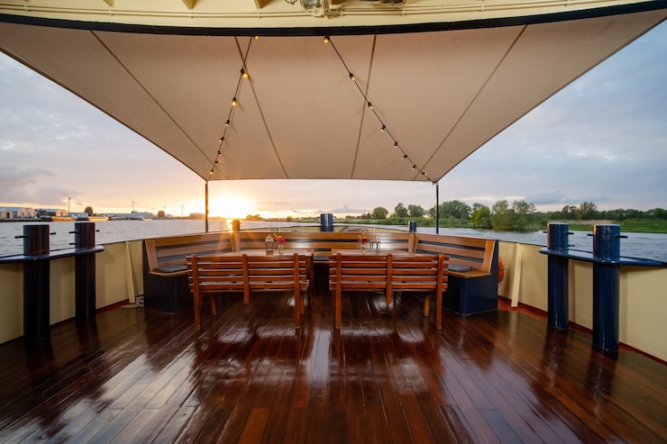 Foto gratuito sillas de madera y las mesas con flores y linternas en la parte superior del barco.