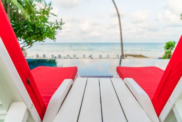 Foto gratuita sillas de playa hermosa con el paraguas en torno a caca de natación al aire libre