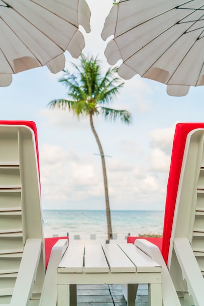 sillas de playa hermosa con el paraguas en torno a caca de natación al aire libre