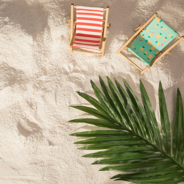 Foto gratuita sillas de playa con palmeras y juguetes.