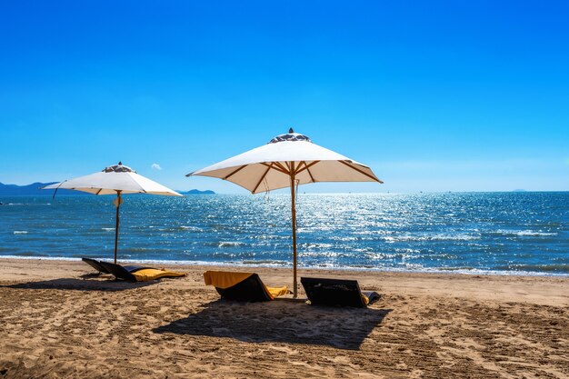 Sillas y sombrillas en una playa tropical.