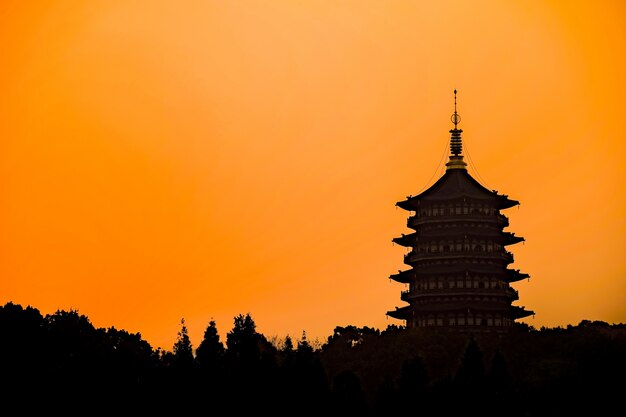 Silueta de construcción oriental con cielo naranja