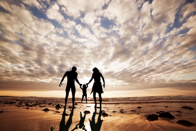 Silueta de familia jugando en la playa