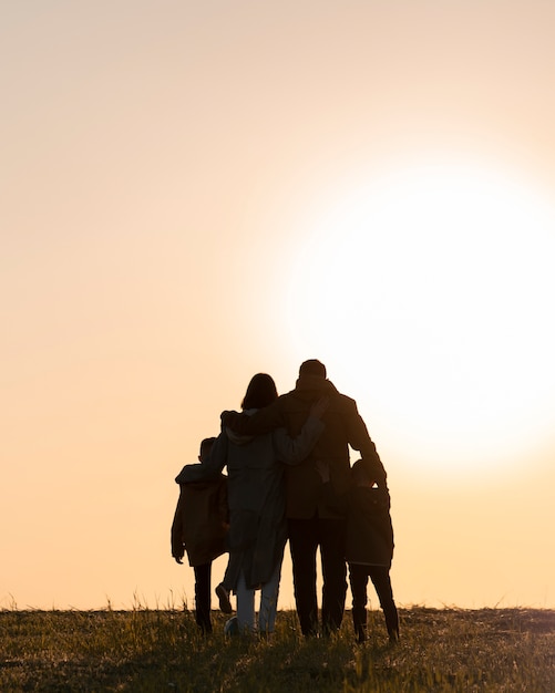 Foto gratuita silueta familiar de tiro completo divirtiéndose al atardecer