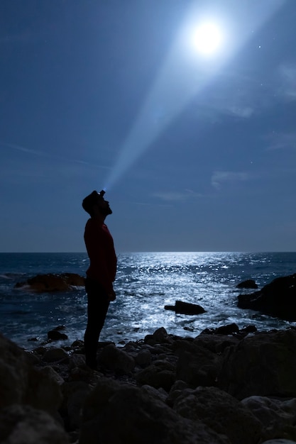 Foto gratuita silueta de un hombre iluminando la luna