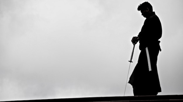 Silueta de un hombre japonés en kimono practicando con una espada katana japonesa tradicional