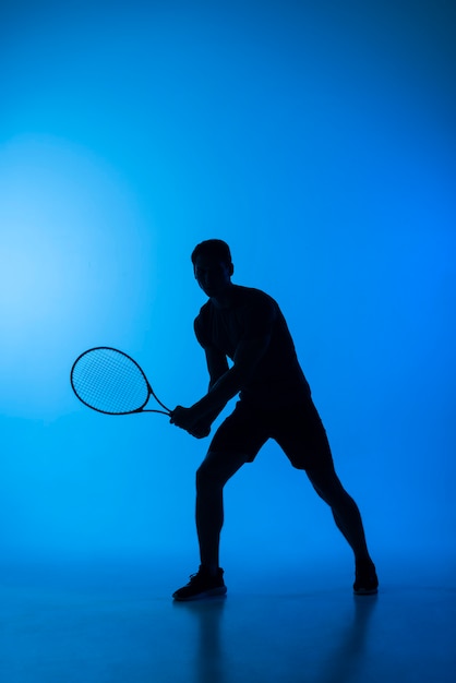 Silueta de hombre de tiro completo jugando al tenis