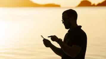 Foto gratuita silueta de hombre de vista lateral en la playa