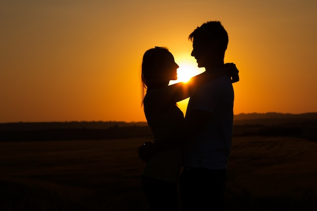 Silueta de joven pareja en el campo.