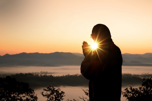 Silueta de la mano cristiana del hombre que ruega, espiritualidad y religión, hombre que ruega a dios.