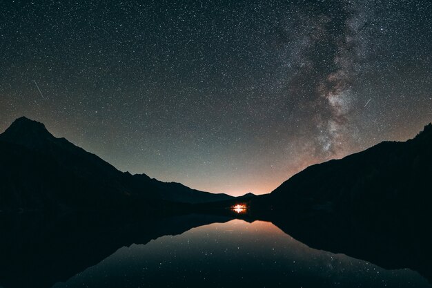 Silueta de montaña y cuerpo de agua tranquila