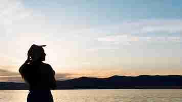 Foto gratuita silueta de mujer al atardecer con montañas