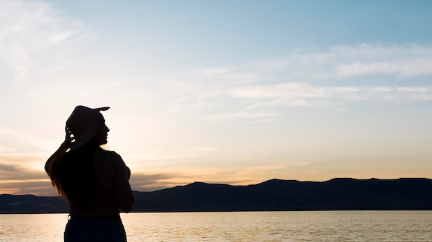 Silueta de mujer al atardecer con montañas