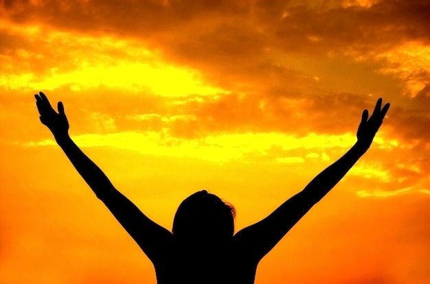 Silueta de mujer feliz en el atardecer