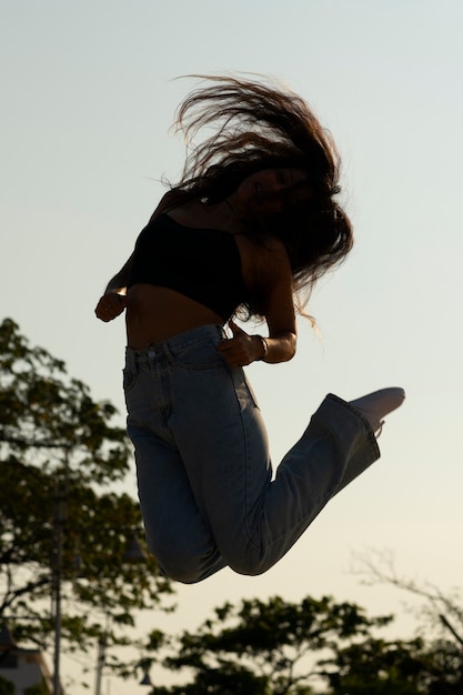 Silueta de mujer de tiro completo saltando al atardecer