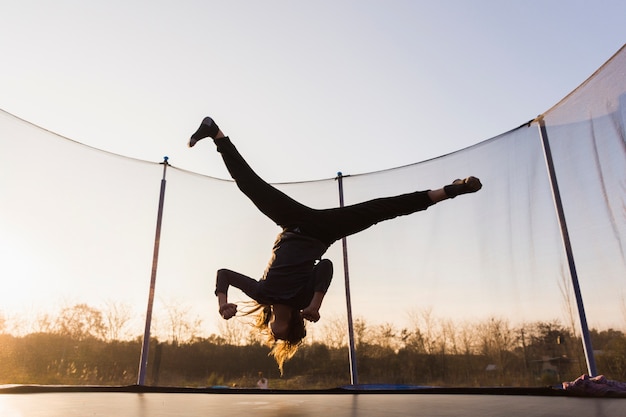 Foto gratuita silueta de niña saltando en un trampolín haciendo split