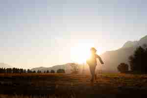 Foto gratuita silueta de niño de tiro completo corriendo en la naturaleza