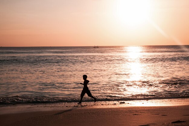 Silueta de niños en Hermosa vista del cielo al atardecer en la playa