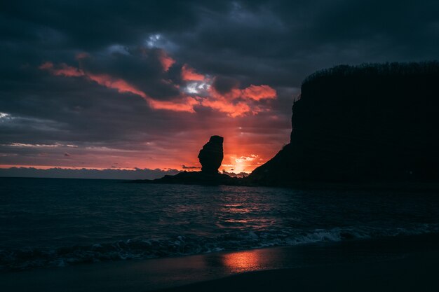 Silueta de una pila de mar contra una colorida puesta de sol en Nueva Caledonia