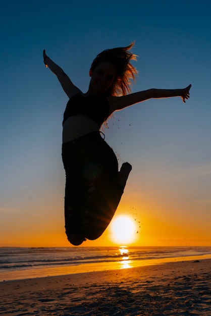 Foto gratuita silueta de tiro completo saltando al atardecer