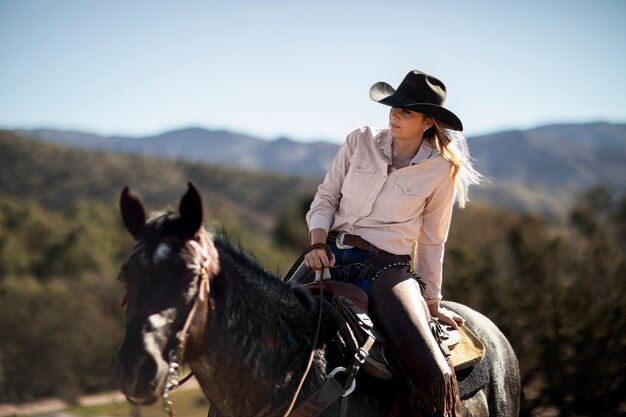 Silueta de vaquero con caballo contra luz cálida