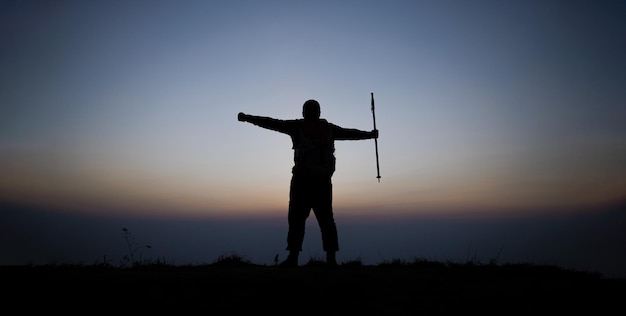 Silueta de vítores senderismo hombre brazos abiertos al soporte del amanecer en la montaña Travel Lifestyle wanderlust concepto de aventura vacaciones de verano al aire libre