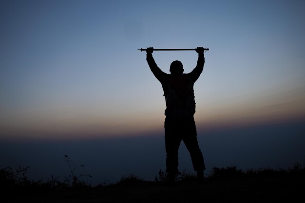 Silueta de vítores senderismo hombre brazos abiertos al soporte del amanecer en la montaña Travel Lifestyle wanderlust concepto de aventura vacaciones de verano al aire libre