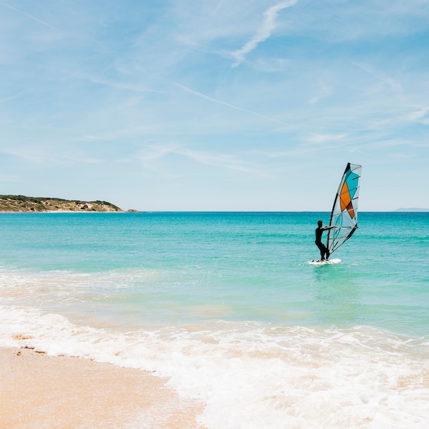 Silueta de un windsurfer en el mar azul.