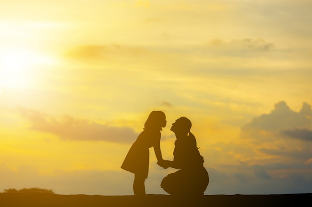 Siluetas de madre e hija jugando al atardecer por la noche | Foto ...