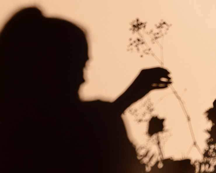 Siluetas de mujer sosteniendo una flor